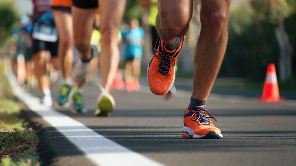 running feet, bright neon orange trainers in foreground