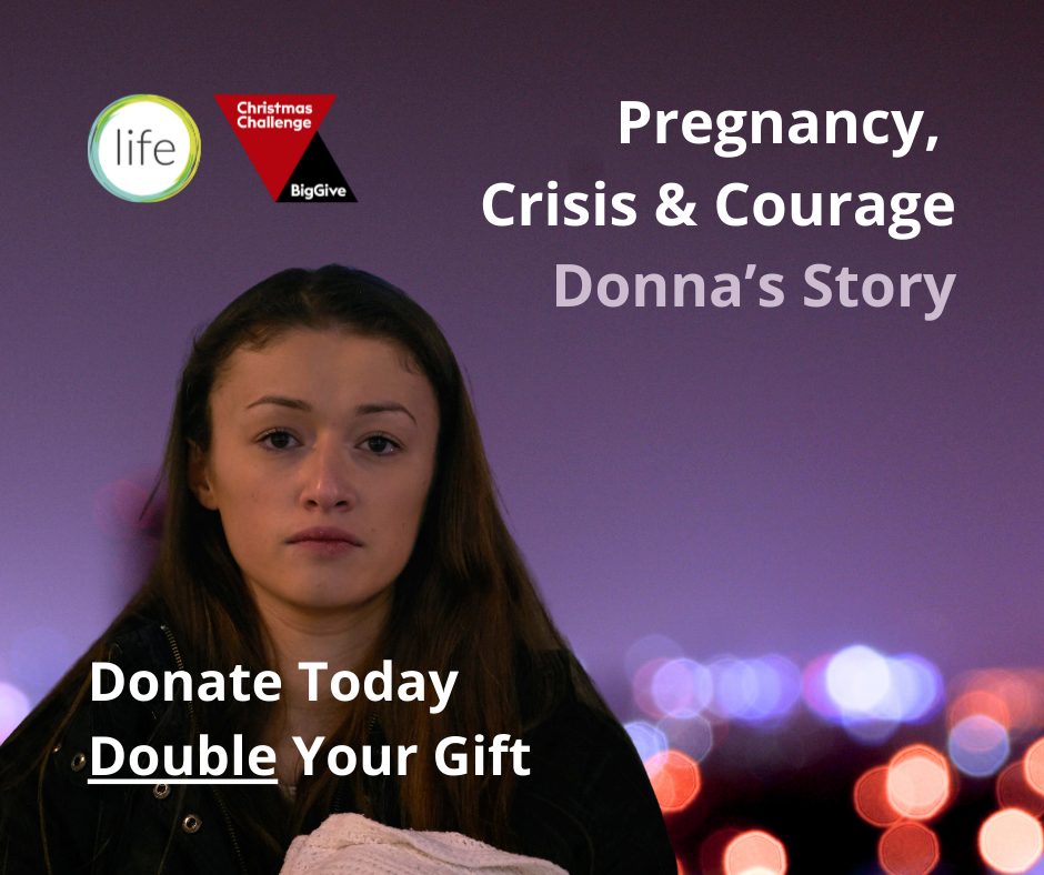 Young woman holding baby at dusk in city scape