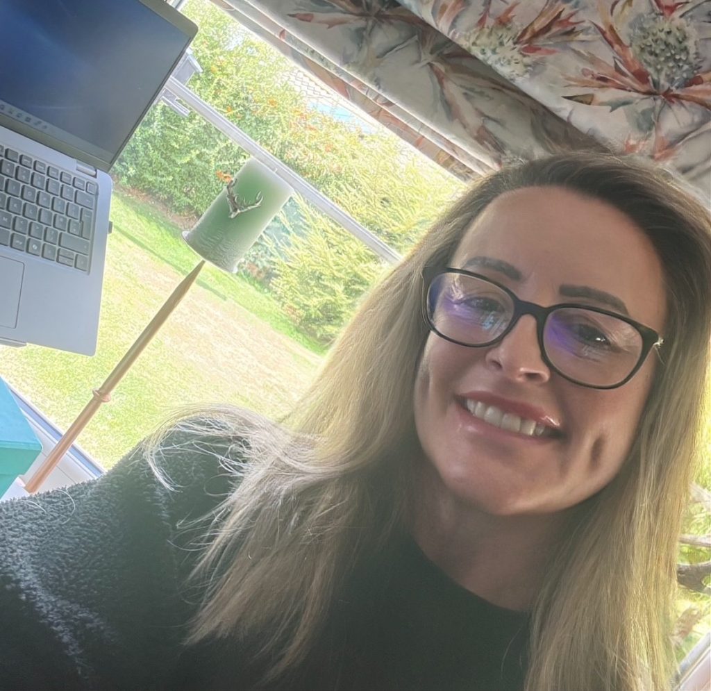 A photo of Life's CEO, Kerry, next to her computer and garden window.
